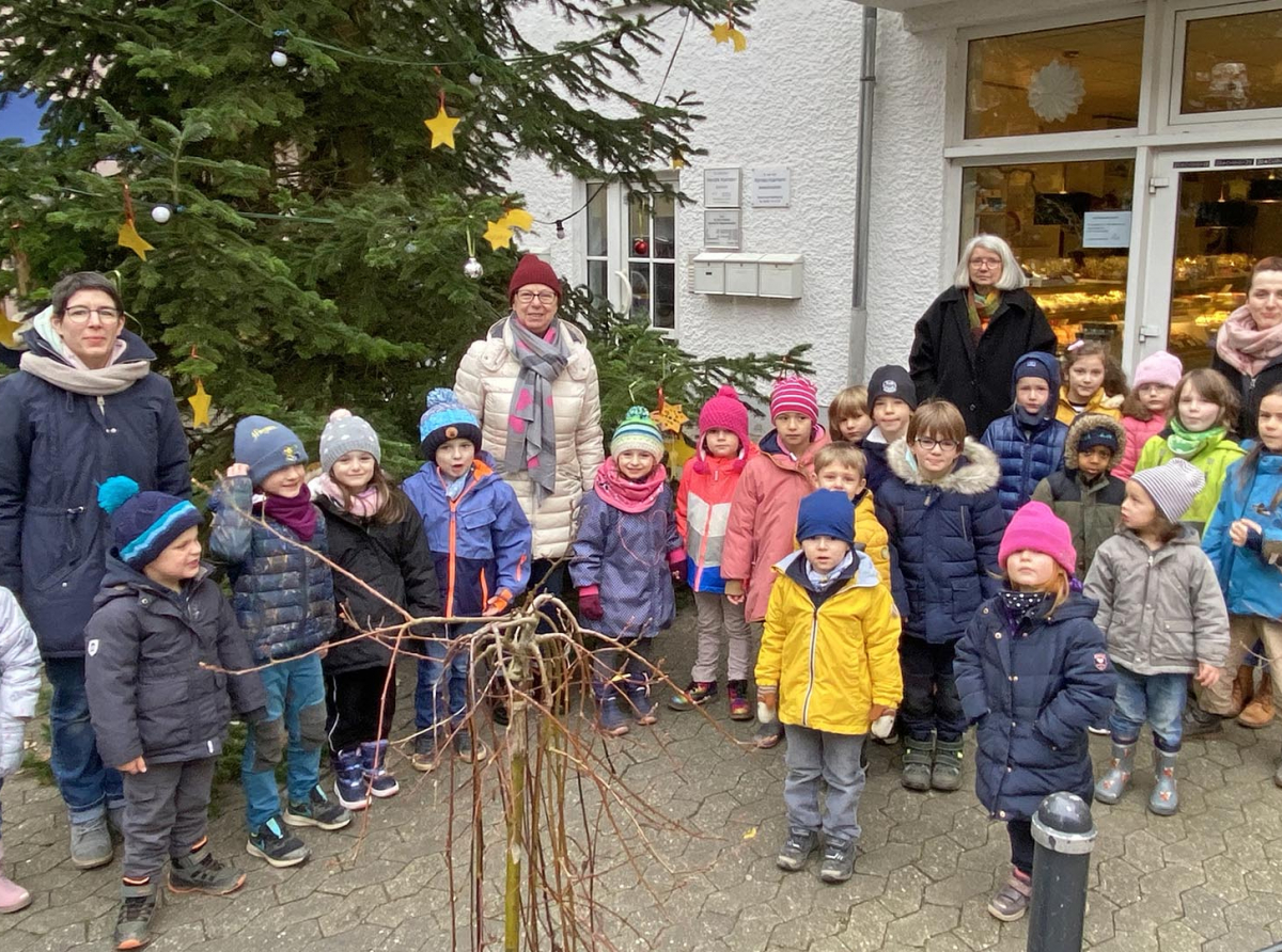 Kindergartenkinder schmücken Weihnachtsbaum am Markt